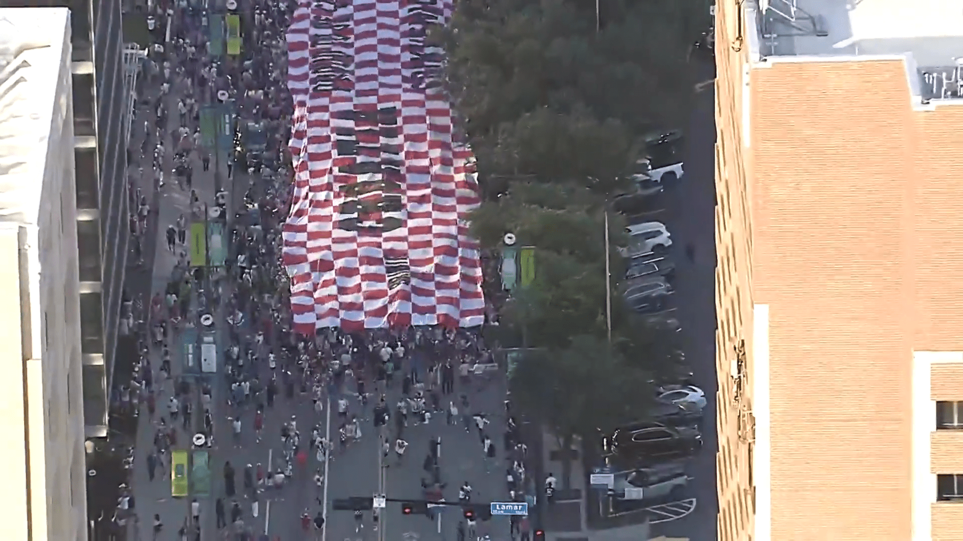 Croatia fans march through Downtown Dallas with a supporter flag. Fans celebrated with parties, parades, and plenty of team spirit.