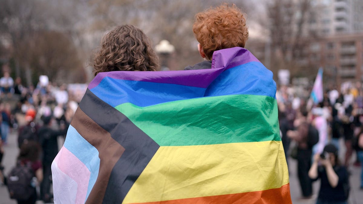 Activists wearing a pride flag