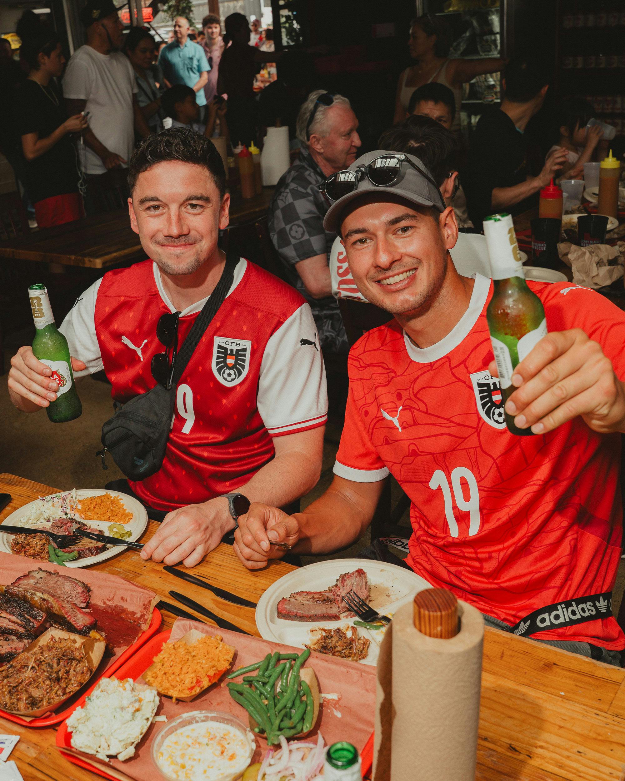 photo of two fans eating barbecue