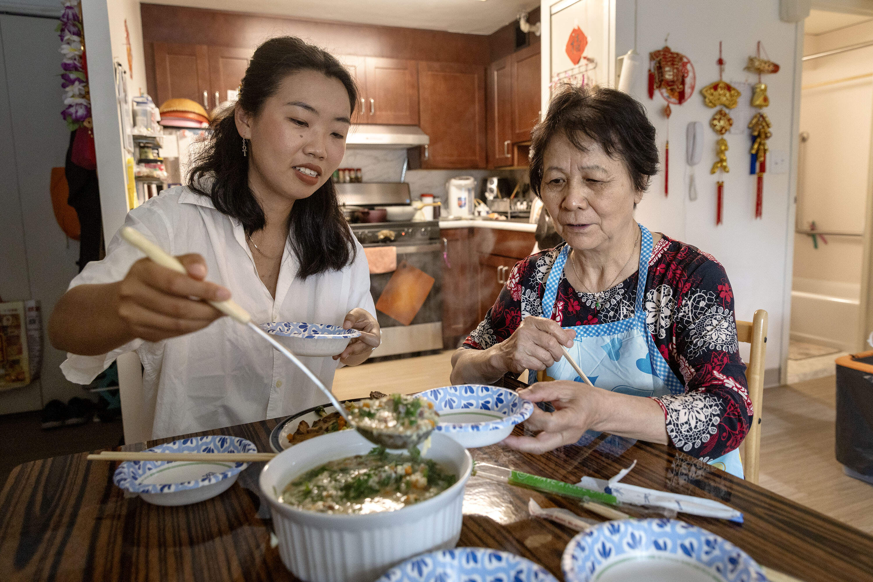 Writer Yolanda Yang dishes out Chinese yam soup made by Lifang Li, one of the "Chinatown Aunties" featured in her book. (Robin Lubbock/WBUR)
