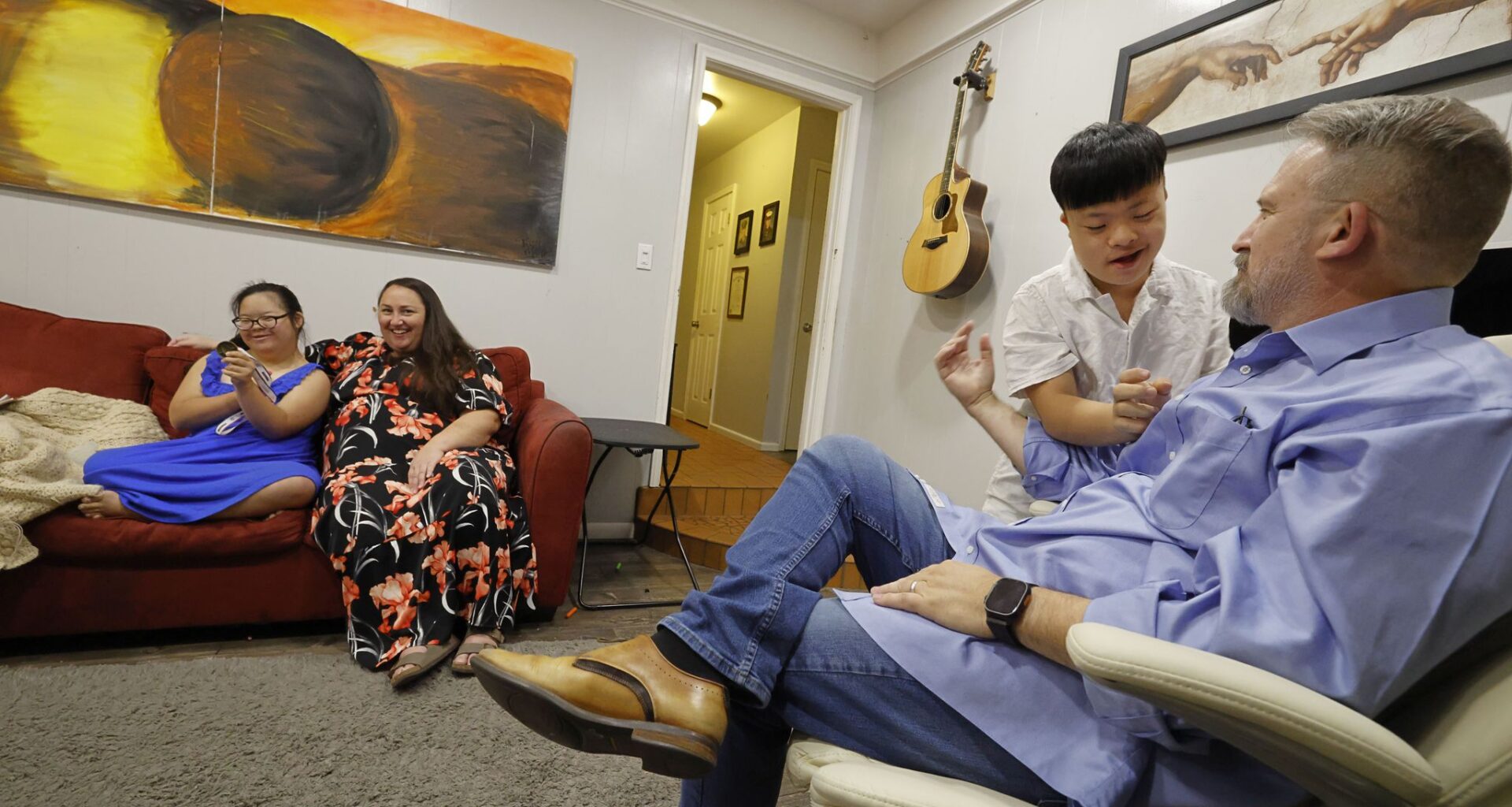 Steven Howk (right) talks with his son Haruki Howk, 14, as his wife Colleen Howk and daughter Yua Howk, 12, sit on a couch together in their home on July 31, 2026, in Hurst.