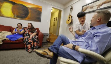 Steven Howk (right) talks with his son Haruki Howk, 14, as his wife Colleen Howk and daughter Yua Howk, 12, sit on a couch together in their home on July 31, 2026, in Hurst.