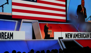 Arlington Mayor Jim Ross introduces Talarico on stage with American Flag in background.