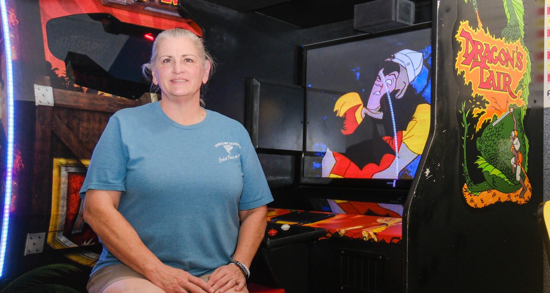 Tornado Terry’s owner Shannon Bell sits beside a custom Dragon’s Lair cabinet built by her late husband, Terry Bell, at the Fort Worth arcade Wednesday, Aug. 5, 2026. 