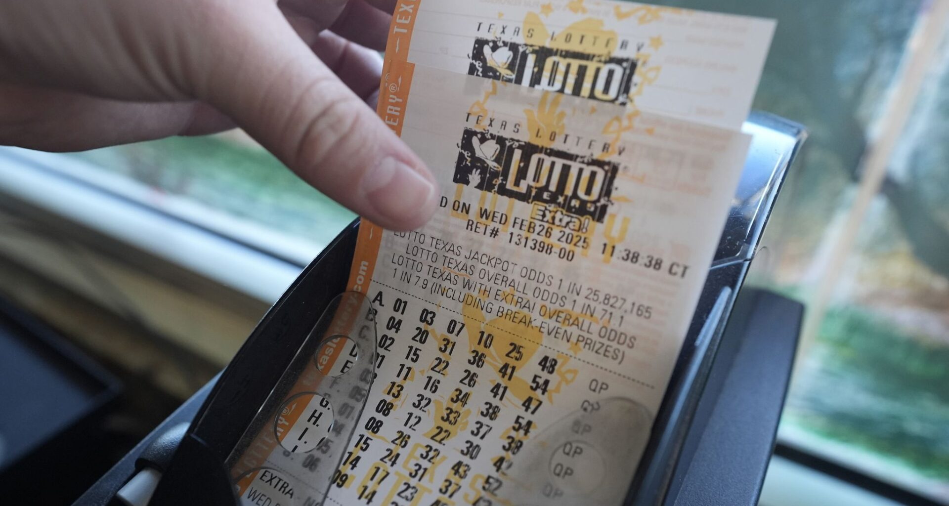 Edith Patlan grabs printed tickets from a Texas Lottery sales terminal at Fuel City in Dallas, Wednesday, Feb. 26, 2025. (AP Photo/LM Otero)