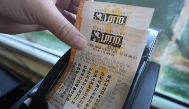Edith Patlan grabs printed tickets from a Texas Lottery sales terminal at Fuel City in Dallas, Wednesday, Feb. 26, 2025. (AP Photo/LM Otero)