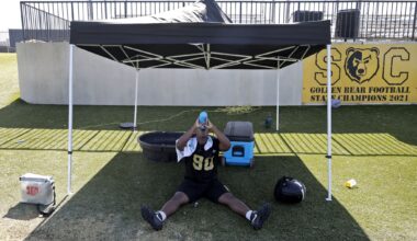 DeAngelo ;Mathis, 16, of Dallas, drinks water in the shade while temperatures heated up as South Oak Cliff High School held their first day of football practice on Monday morning, August 10, 2026.