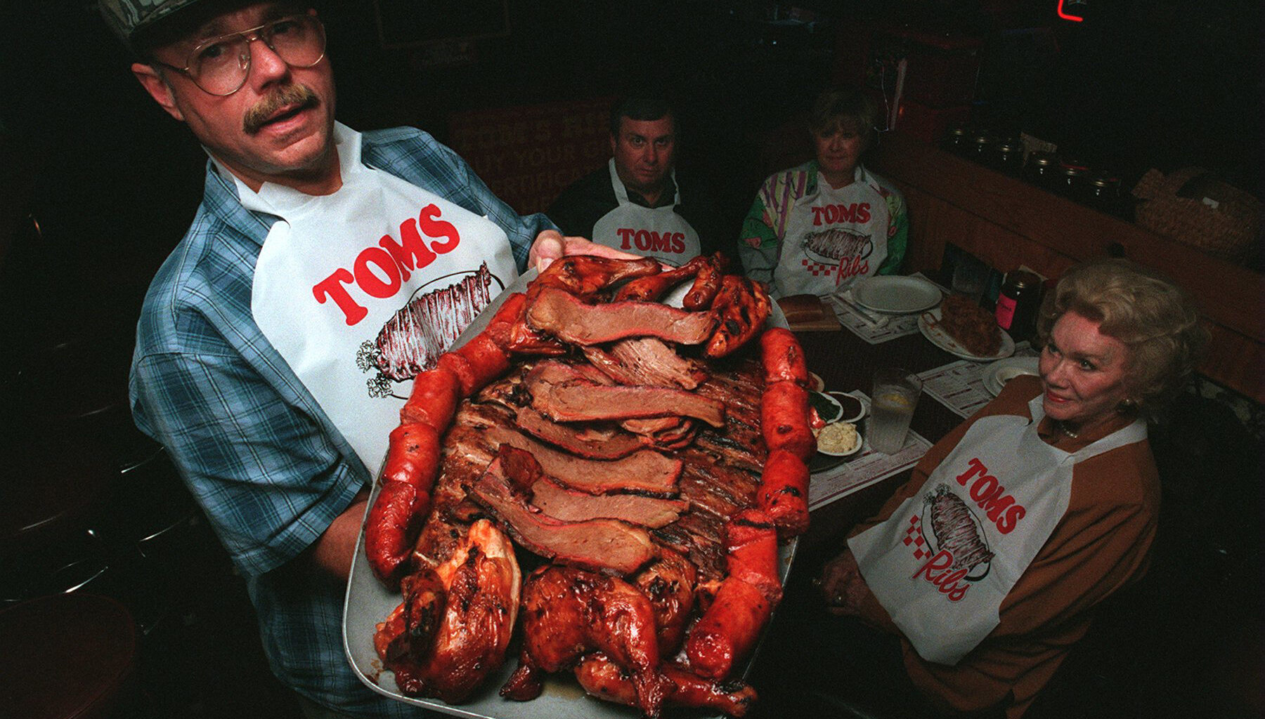 Tom's Ribs founder Tom Norris holds one of his specialty barbecue plates in 1998.