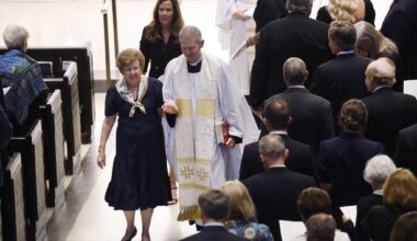 The Reverend Dr. Christopher D. Girata escorts Pam Luce, widow of the late Tom W. Luce III, from Saint Michael and All Angels Episcopal Church sanctuary following a service for her husband in Dallas, August 15, 2026. The influential Dallas attorney, public policy reformer, and civic leader passed away at the age of 86.