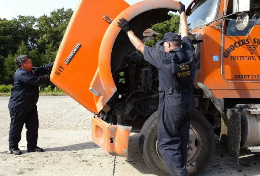 DPS Troopers Frank Martinez, left, and George Harris inspect a tractor trailer at a checkpoint outside Terrel as part of an intense 72-hour inspection period for 18-wheelers.