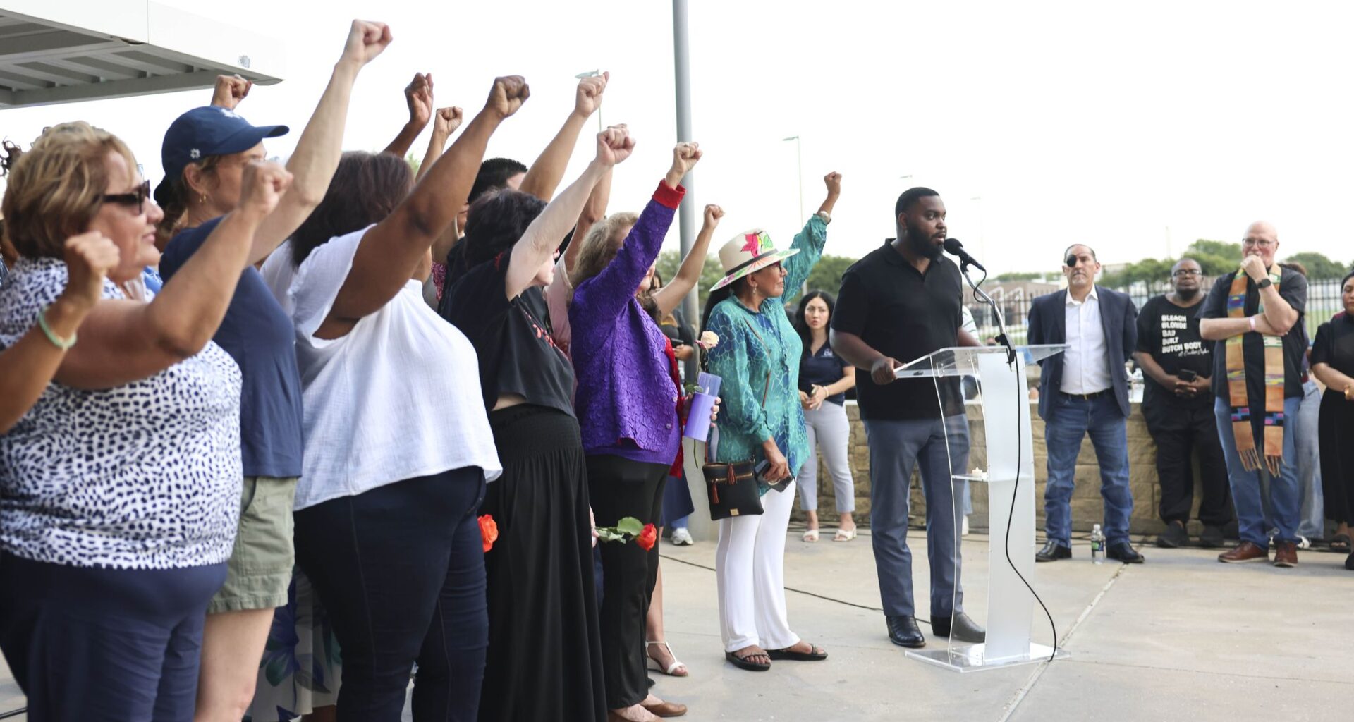 Community members raise their fist remembering Sylvia Collins who lost life in a north Oak Cliff apartment complex fire, Friday, May 29, 2026 in Dallas.