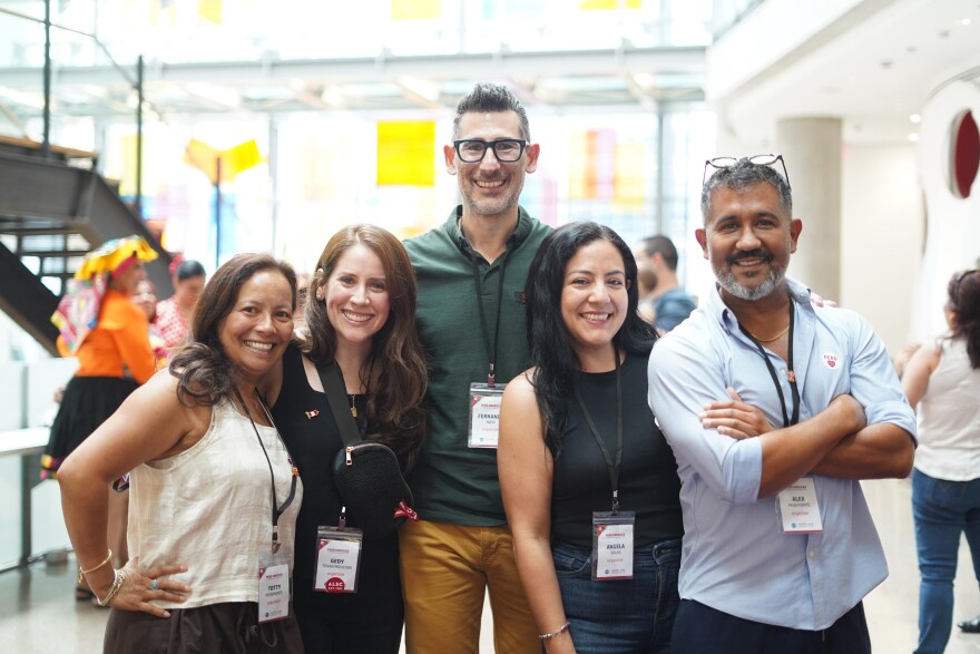 A group of five people smile for the camera.