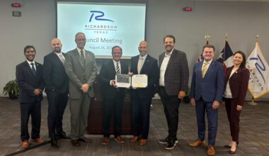 Photo shows the Richardson City Council with the Richardson City Manager in the middle. 
