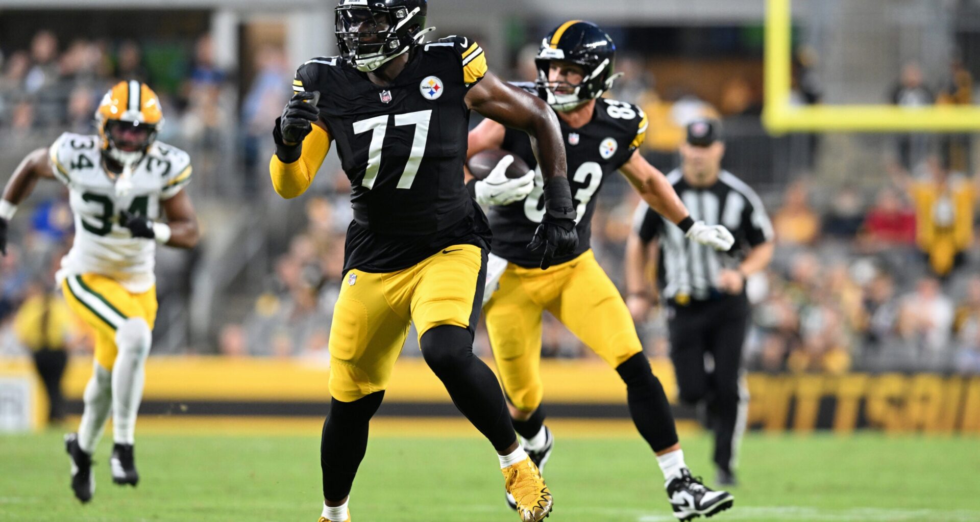 Aug 13, 2026; Pittsburgh, Pennsylvania, USA; Pittsburgh Steelers offensive tackle Broderick Jones (77) looks for someone to block as tight end Robert Tonyan (83) carries the ball during the first half of a game against the Green Bay Packers at Acrisure Stadium.