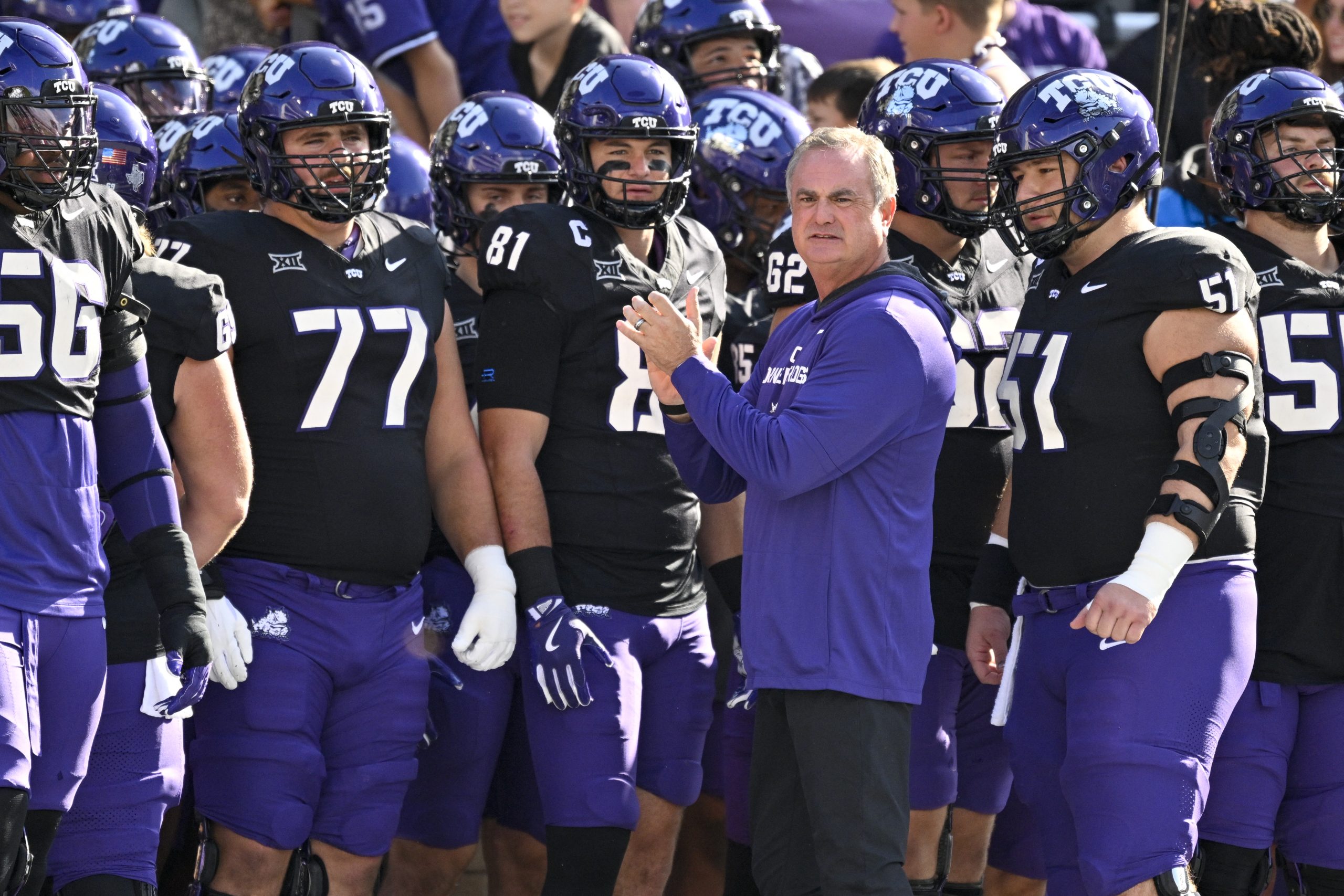 Sonny Dykes claps his hands in front of a group of TCU players