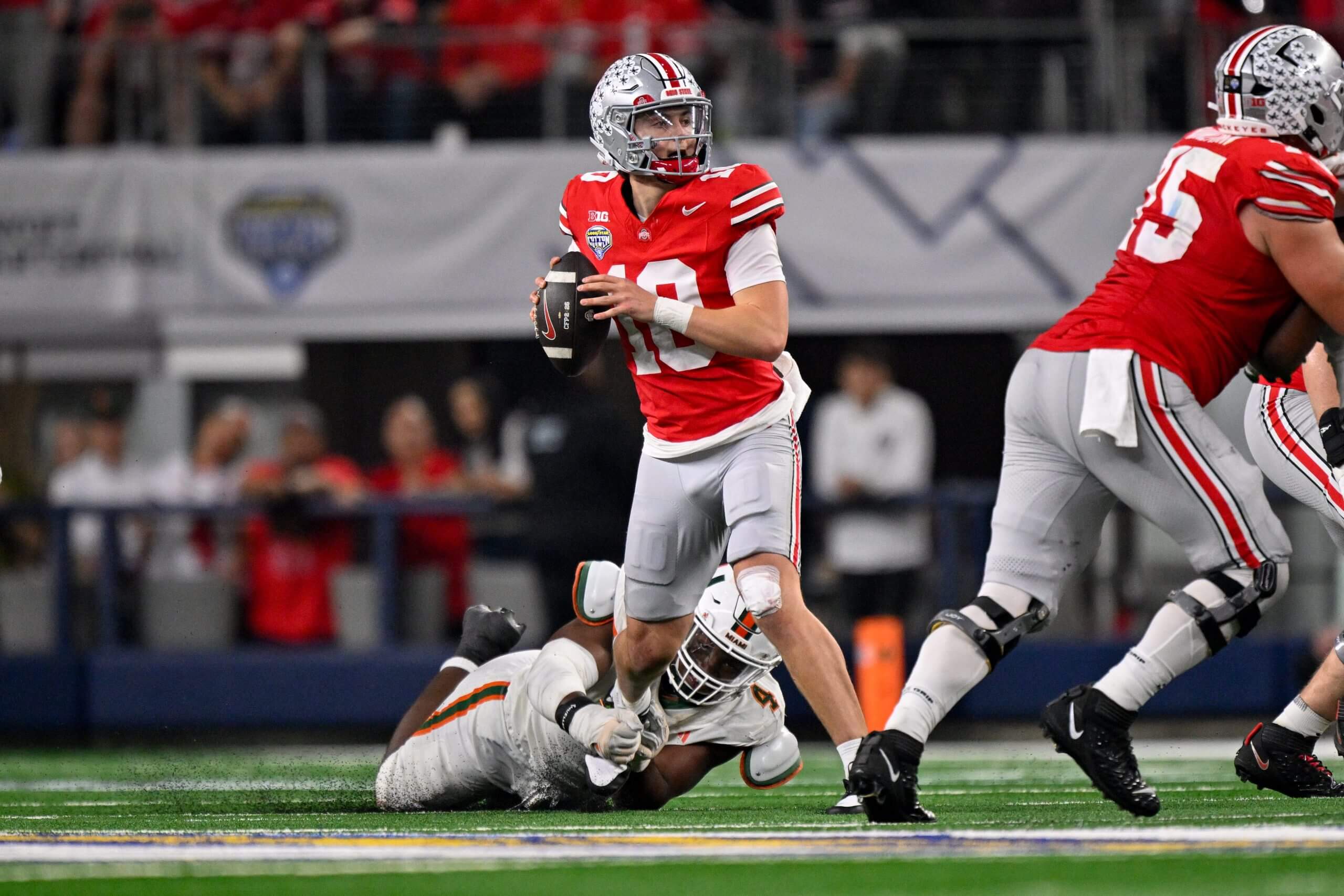 Julian Sayin looks down the field with a defender grabbing his leg.