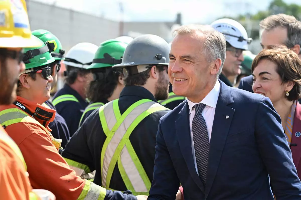 Canadian Prime Minister Mark Carney meets workers at the Davie shipyard in Levis, Monday, Aug. 24, 2026. (Jacques Boissinot/The Canadian Press via AP)