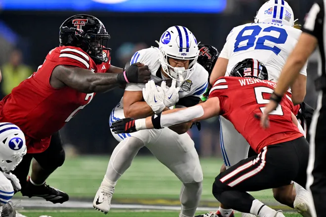 Dec 6, 2025; Arlington, TX, USA; BYU Cougars running back LJ Martin (4) is tackled by Texas Tech Red Raiders defensive back Cole Wisniewski (5) during the first half at AT & T Stadium. Mandatory Credit: Jerome Miron-Imagn Images