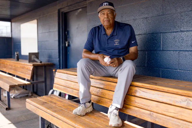 Juan “Choppy” Orozco, a longtime Coronado High School baseball coach and assistant football coach who is retiring after 47 years, sits in the dugout for a portrait Wednesday, Aug. 12, 2026, at Coronado High School in West El Paso, Texas.