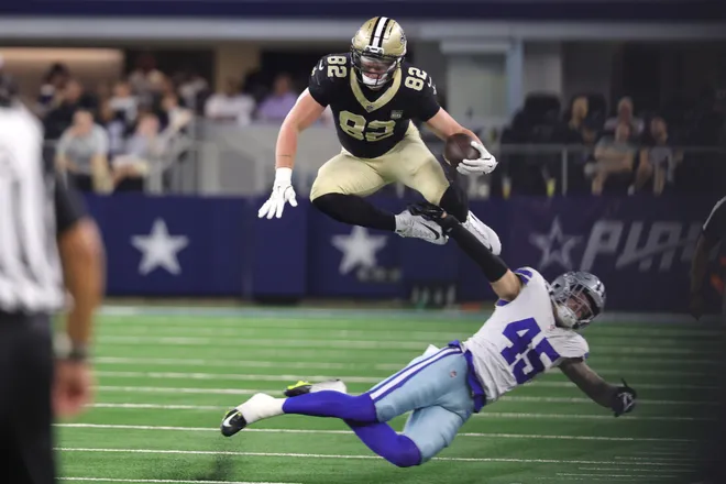 Aug 28, 2026; Arlington, Texas, USA; New Orleans Saints tight end Treyton Welch (82) jumps over Dallas Cowboys linebacker Justin Barron (45) during the first half at AT & T Stadium. Mandatory Credit: Kevin Jairaj-Imagn Images