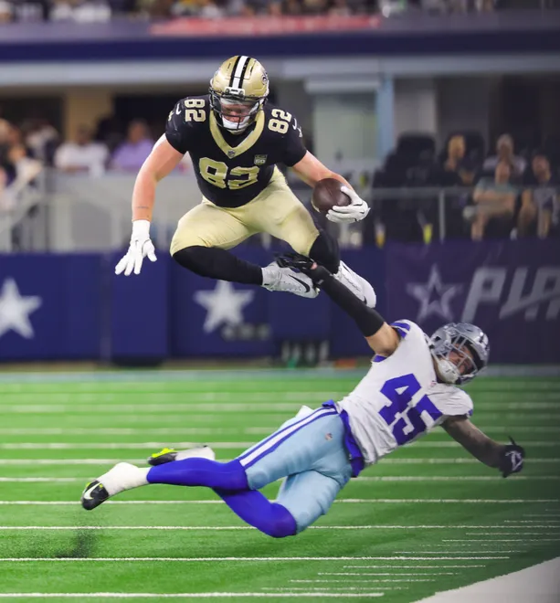 Aug 28, 2026; Arlington, Texas, USA; New Orleans Saints tight end Treyton Welch (82) jumps over Dallas Cowboys linebacker Justin Barron (45) during the first half at AT & T Stadium. Mandatory Credit: Kevin Jairaj-Imagn Images