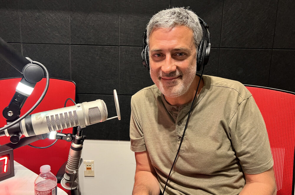 Andrea Bajani wearing headphones next to a microphone