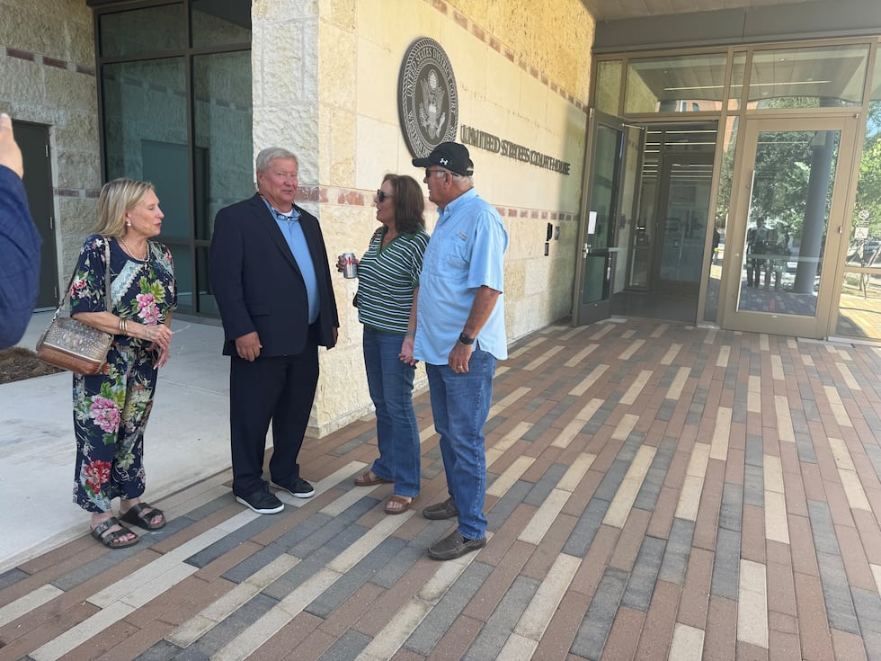 Victims Jay Adkins (on left in suit) and Susan and Terry Hunter (right) celebrate the verdict...