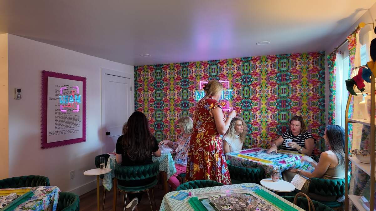 Instructor Lindsay Yanaway chats with The Mahj Clubhouse players, topping off their champagne and debriefing the previous weekend’s tournament on Tuesday, June 30, 2026.