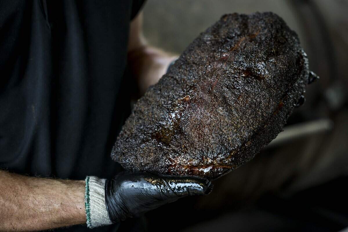 Alex Cobb pulls brisket off the smokers at Dayne's Craft Barbecue on Saturday, Aug. 15, 2026 in Aledo.