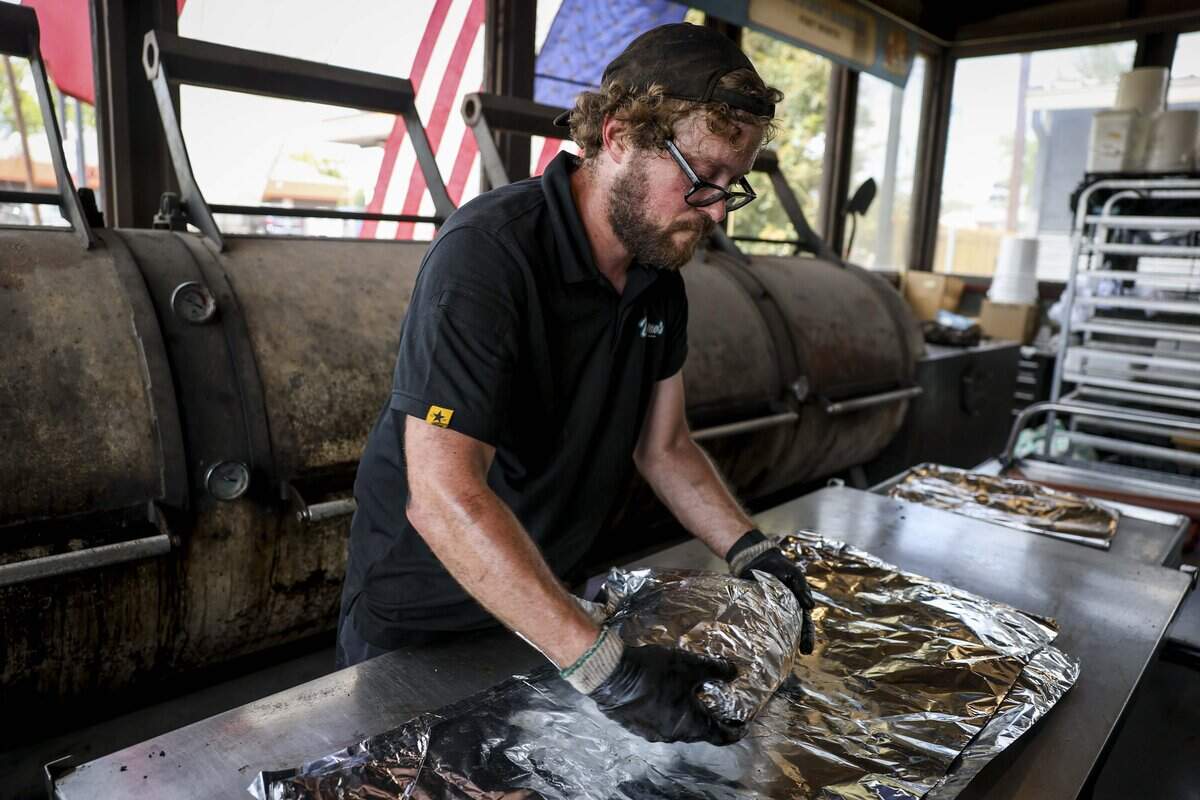 Alex Cobb pulls brisket off the smokers at Dayne's Craft Barbecue on Saturday, Aug. 15, 2026 in Aledo.