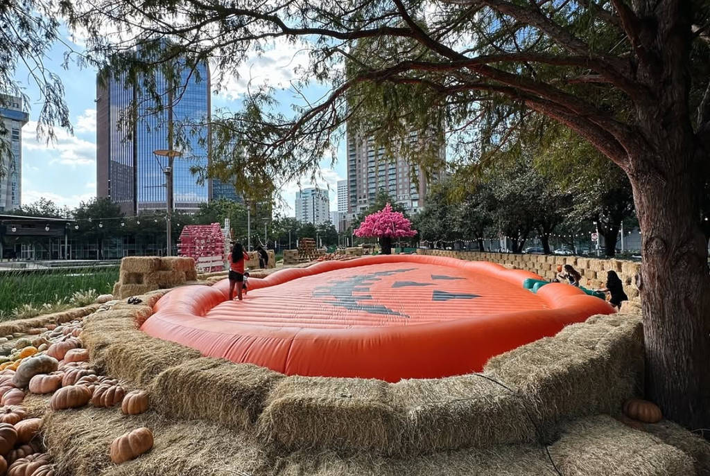 Image shows the giant pumpkin bouncing place at Houston Pumpkin Festival in Discovery Green