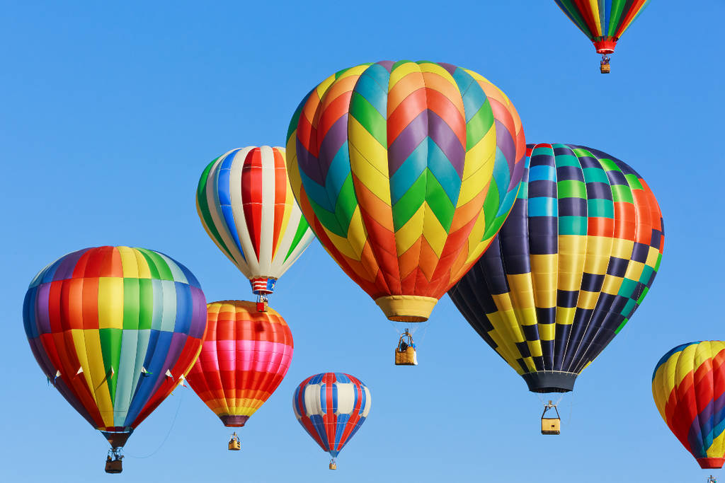 Image shows a fleet of hot air balloons in the sky