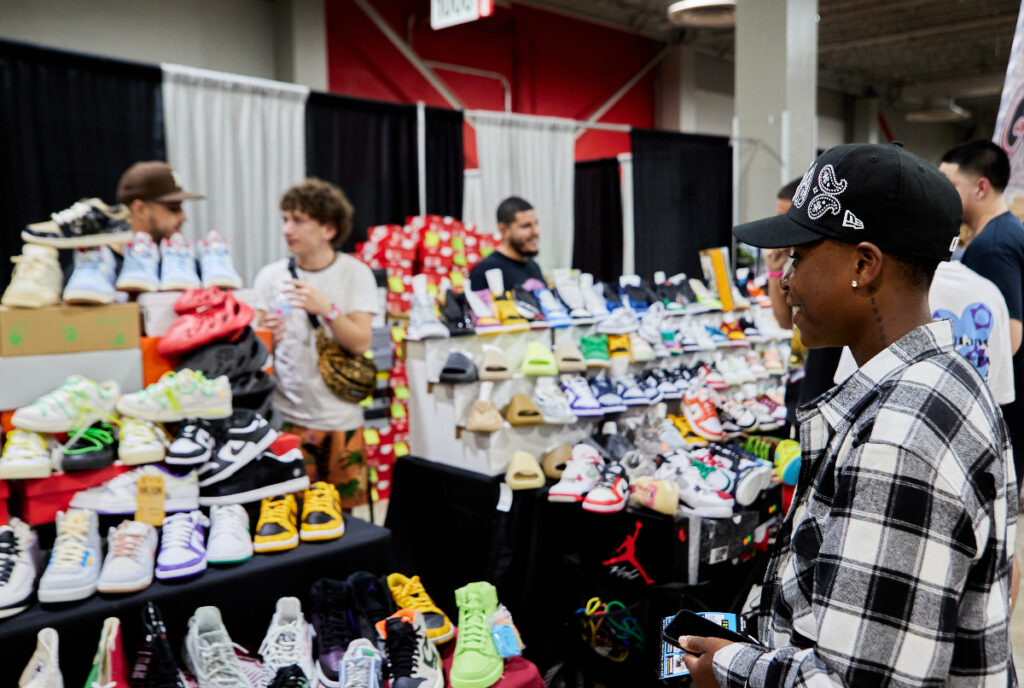 Image shows a visitor attending a sneaker convention of sorts.