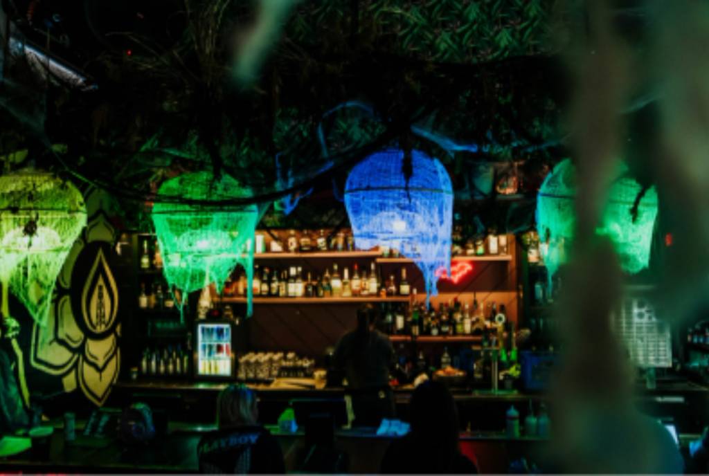 Image shows the interior of a bar during the Black Lagoon pop-up featuring decor and moody lighting fixtures.