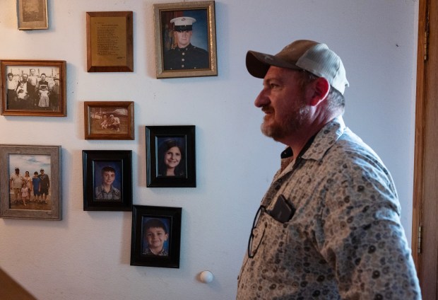 Daniel McCoslin stands next to family photos dating back to when his ancestors settled Texas. (Antranik Tavitian/For The Washington Post)