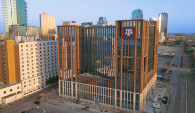 The Law and Education Building from a distance; tall buildings in downtown Dallas behind it