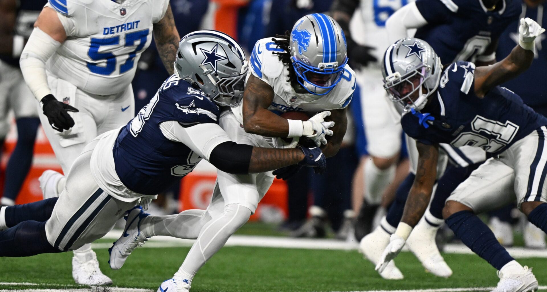 Dec 4, 2025; Detroit, Michigan, USA; Detroit Lions running back Jahmyr Gibbs (0) is tackled by Dallas Cowboys defensive tackle Quinnen Williams (92) during the first half at Ford Field.