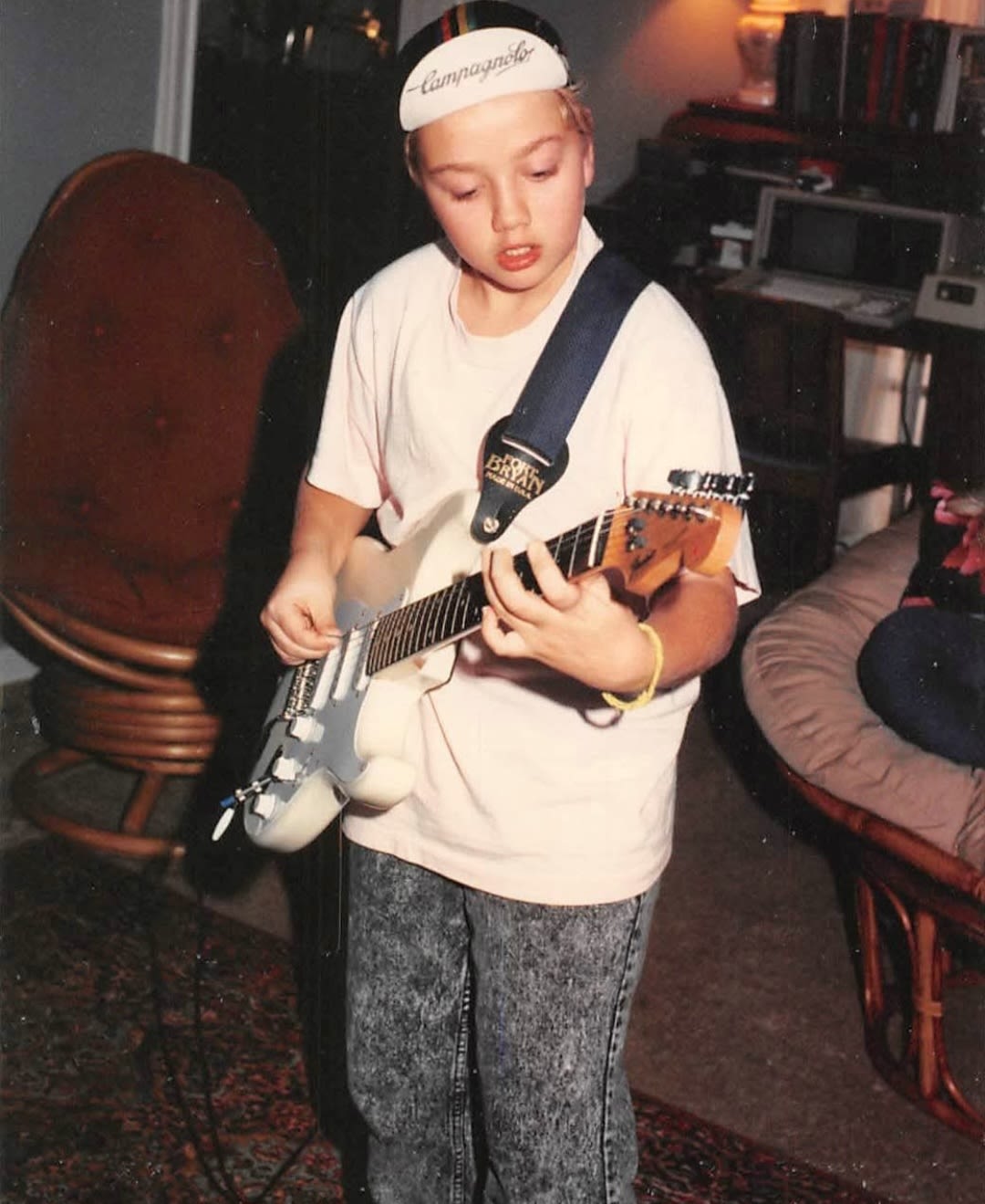 A photo of a child playing guitar in the 1980s.