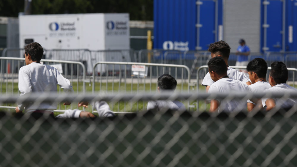 Migrant children run around a track outside at the Homestead Temporary Shelter for Unaccompanied Children in Homestead, Fla. Shelters that house these children are reaching capacity and the federal government is now working to speed releases to sponsors.