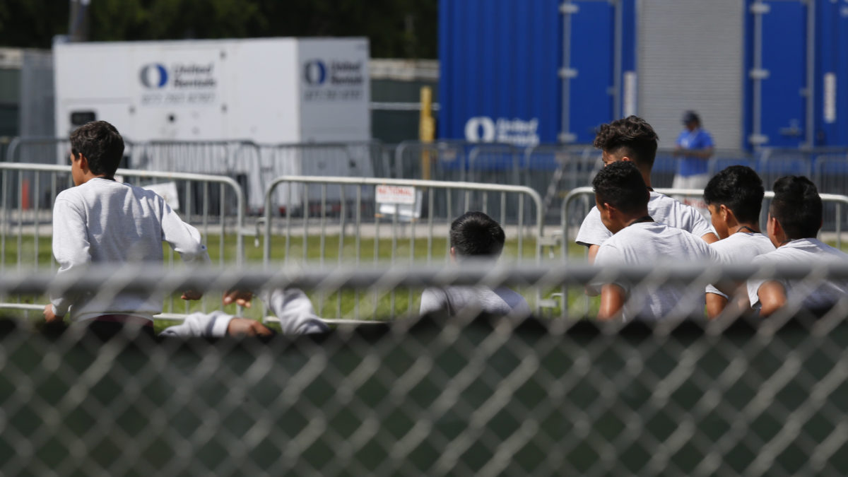 Migrant children run around a track outside at the Homestead Temporary Shelter for Unaccompanied Children in Homestead, Fla. Shelters that house these children are reaching capacity and the federal government is now working to speed releases to sponsors.