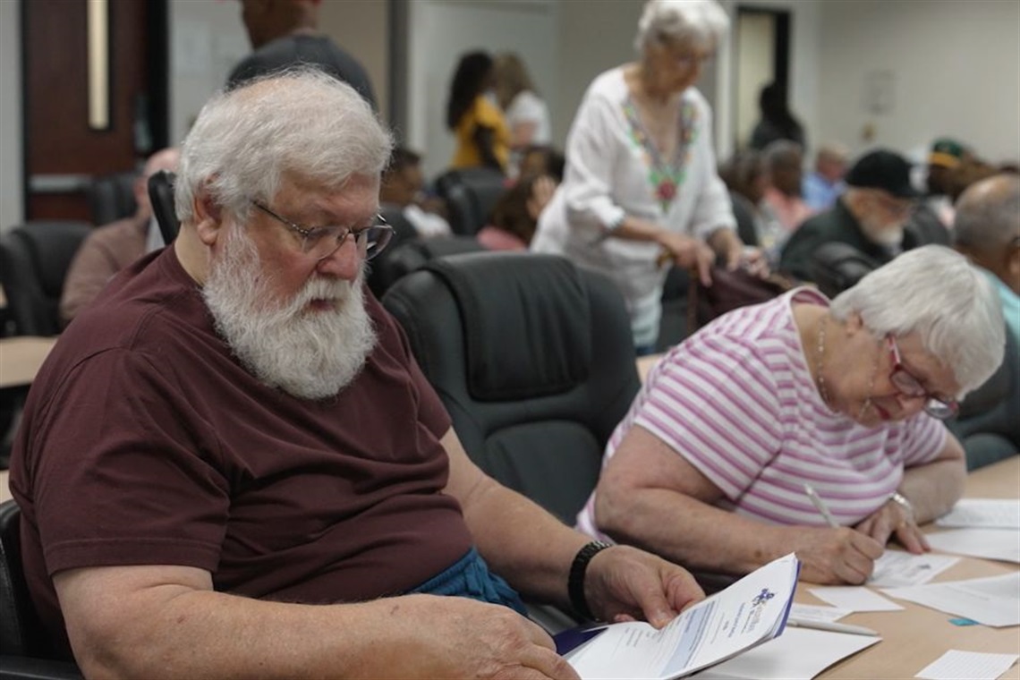 Two seniors in a table looking at papers