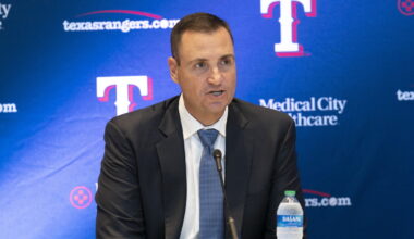Texas Rangers general manager Chris Young speaks into a microphone in front of a Rangers backdrop at Globe Life Field.