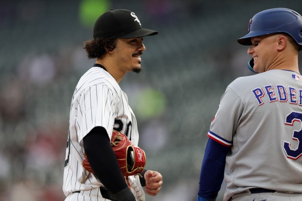 White Sox third baseman Miguel Vargas (20) laughs with Rangers designated hitter Joc Pederson (3) during the first inning against the Rangers at Rate Field Aug. 24, 2026 in Chicago. (Armando L. Sanchez/Chicago Tribune)