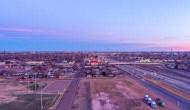 A view of Lubbock, Texas, with buildings, highways, and vehicles during twilight.