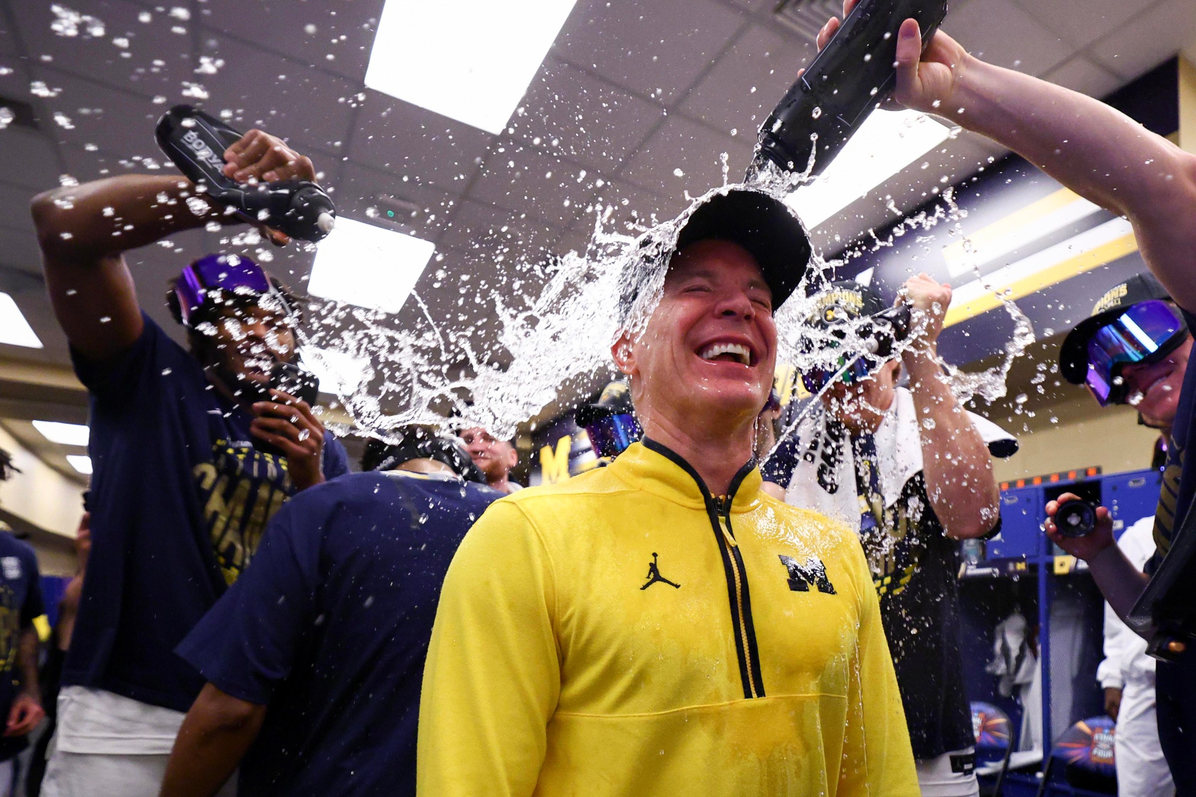 INDIANAPOLIS, INDIANA - APRIL 06: Head Coach Dusty May of the Michigan Wolverines is doused with water in the lockerroom after Michigan defeated the UConn Huskies in the National Championship of the 2026 NCAA Men’s Basketball Tournament at Lucas Oil Stadium on April 06, 2026 in Indianapolis, Indiana. (Photo by Jamie Schwaberow/NCAA Photos via Getty Images)