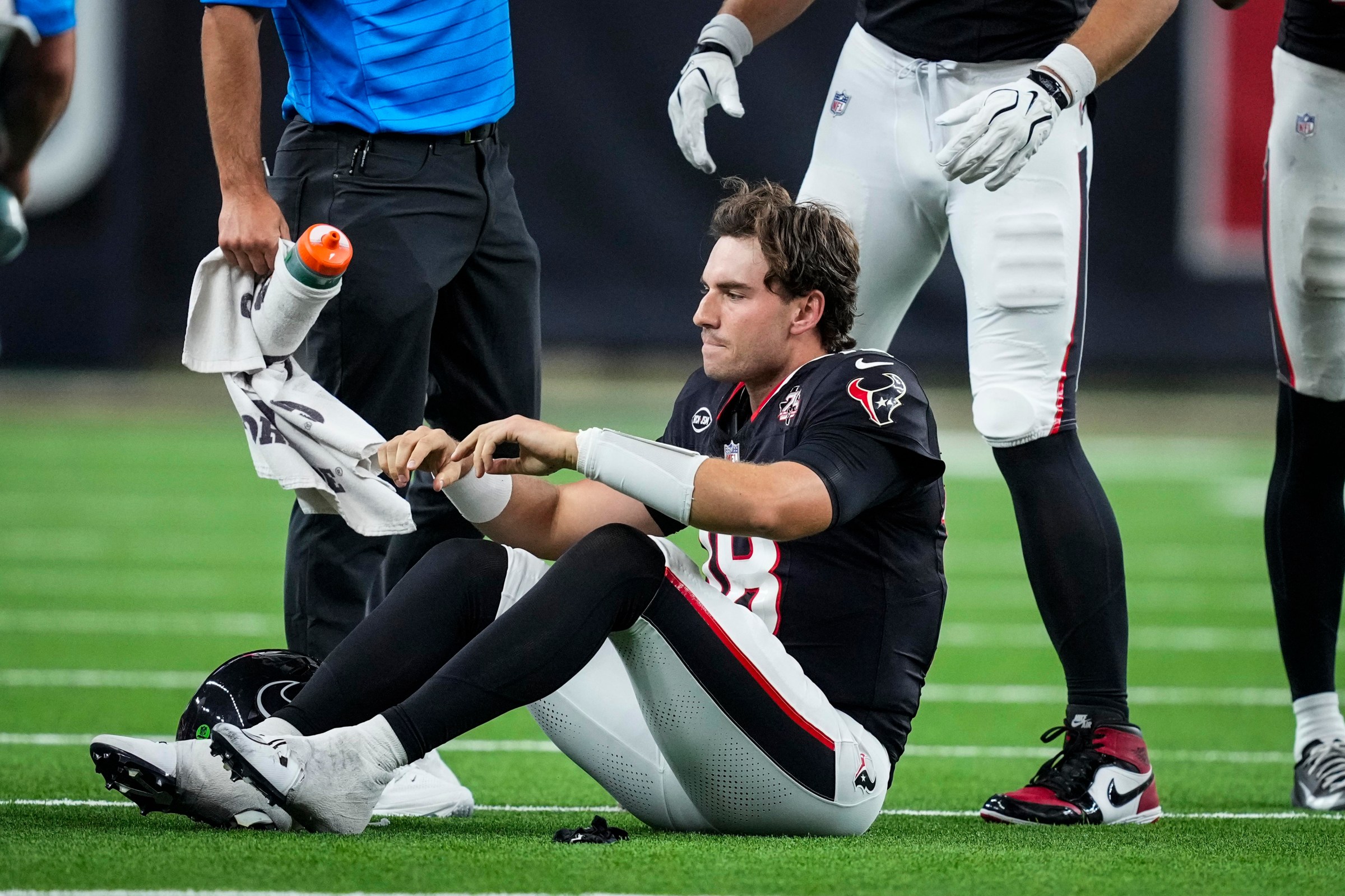 Houston Texans quarterback Graham Mertz (18) sits on the turf after he suffered an injury on a scramble against the Los Angeles Chargers during the first half of an NFL pre-season football game at Reliant Stadium in Houston, Thursday, Aug. 13, 2026. (Photo by Brett Coomer/Houston Chronicle via Getty Images)
