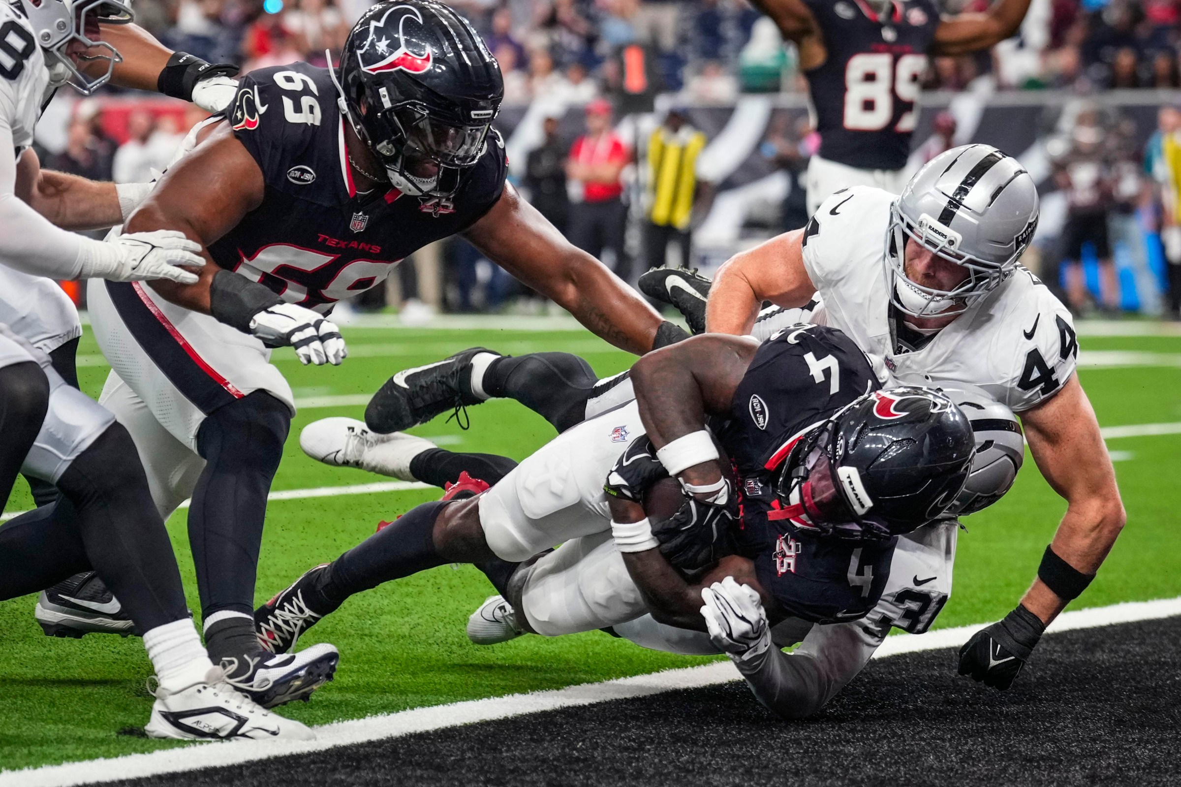 Houston Texans running back Woody Marks (4) dives across the goal line past Las Vegas Raiders linebacker Tommy Eichenberg (44) on a 20-yard touchdown run during the first half of an NFL preseason football game at Reliant Stadium in Houston, Thursday, Aug. 20, 2026. (Photo by Brett Coomer/Houston Chronicle via Getty Images)