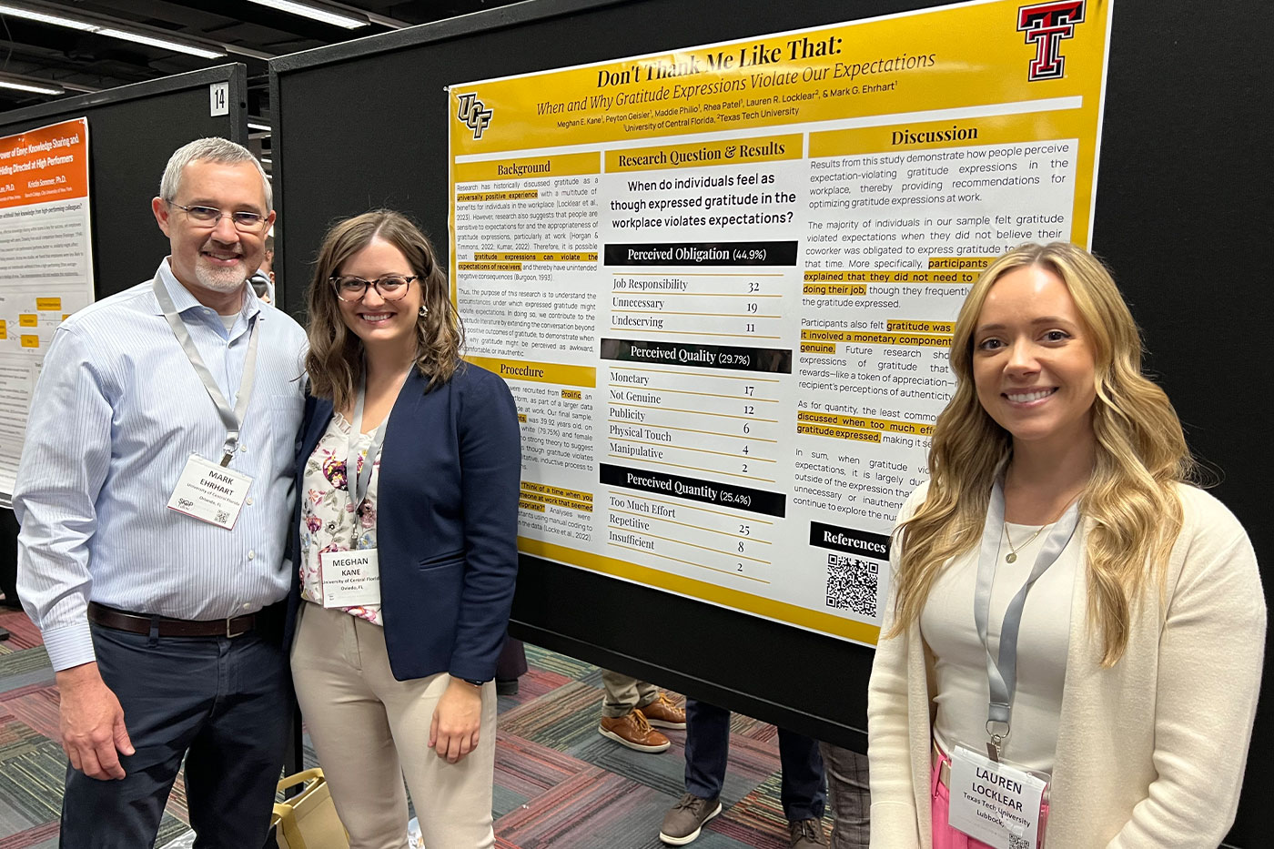 Three researchers wearing conference badges pose next to a yellow-and-white academic poster about gratitude expressions and workplace expectations.