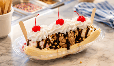 Delicious banana split with whipped cream, cherries, and chocolate drizzle.