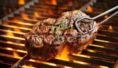 A steak on a grill held by tongs.